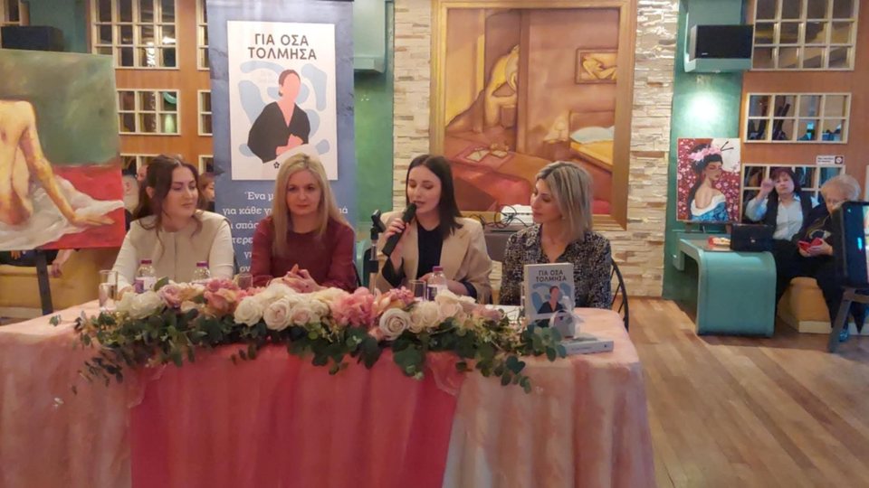 Τέσσερις γυναίκες στο πάνελ μιας παρουσίασης, με λουλούδια στο τραπέζι.
